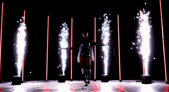 a woman is standing in front of a row of fireworks ..