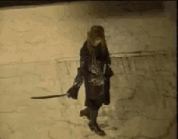 a woman in a black coat is walking in the snow holding a sword