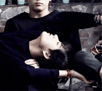 a man and a woman are laying on top of each other on a chair .