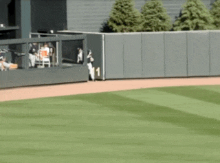 a baseball field with a fence and a player wearing a number 1 jersey