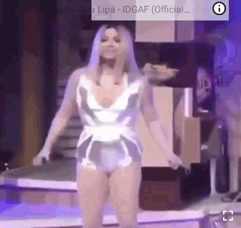 a woman in a very revealing outfit is dancing on a stage in front of a sign that says idgaf official