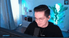 a man wearing glasses is sitting in front of a computer .
