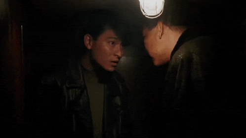 a man smoking a cigarette while another man holds him