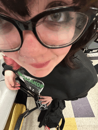 a girl wearing glasses and a t-shirt that says komakob