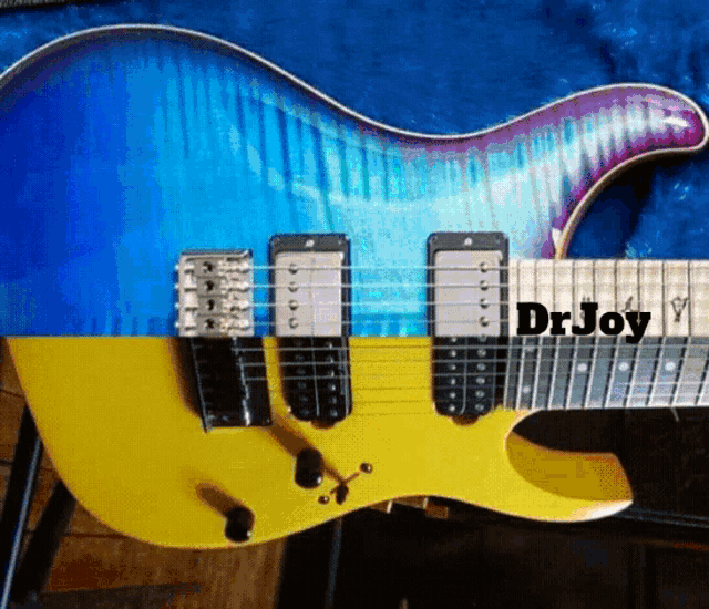 a yellow and blue electric guitar with the name dr joy on the neck