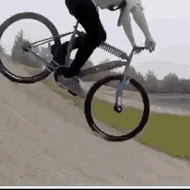 a person is riding a bike on a dirt road .