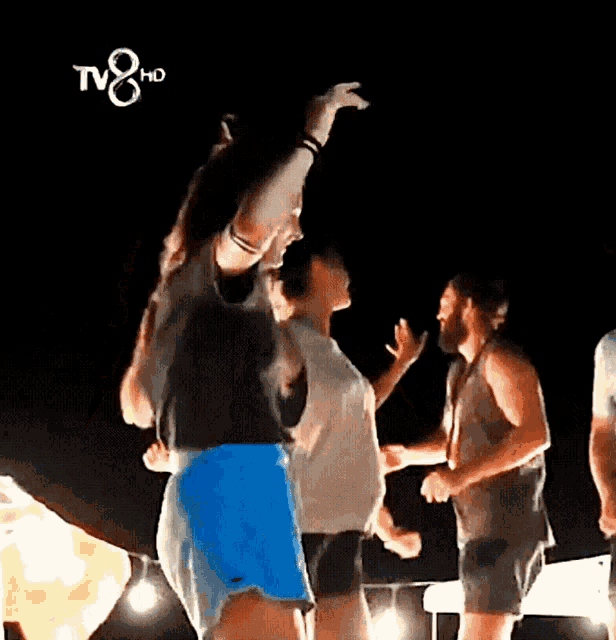 a group of people are dancing in front of a tv8 hd logo