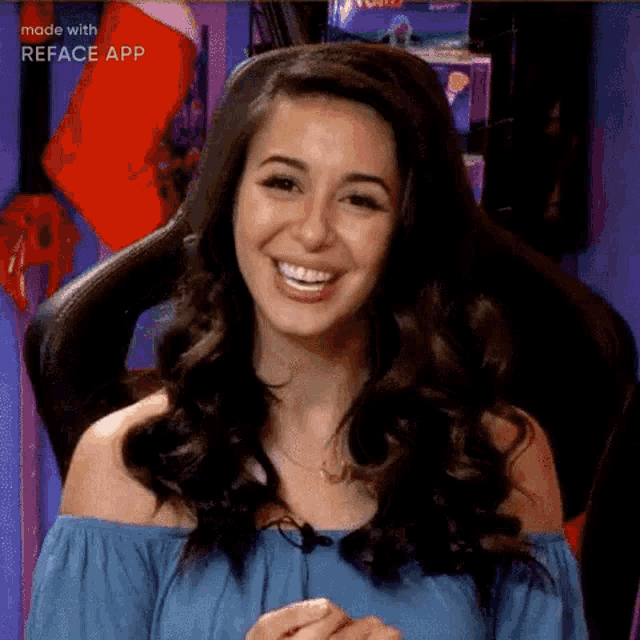 a woman is smiling while sitting in a chair with a microphone .