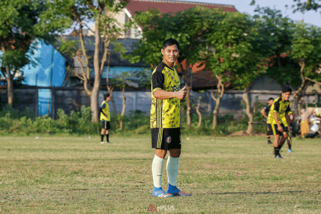 a soccer player wearing a yellow and black shirt with the word plus on it