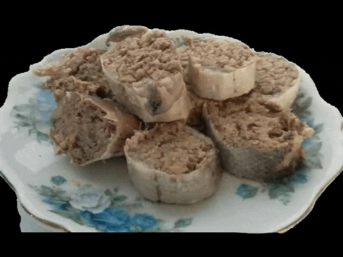 a white plate with blue flowers on it has a bunch of meat on it