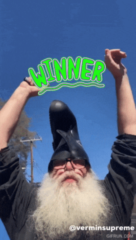 a man with a beard is wearing a helmet and holding up the word winner