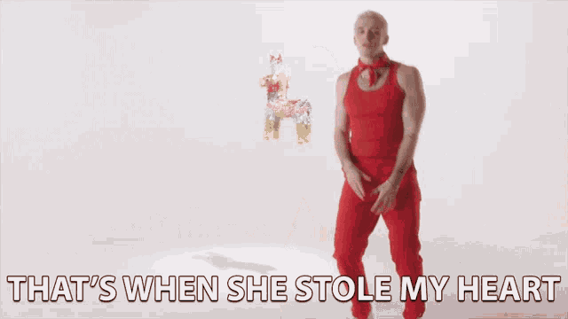 a man in red pants is dancing with the words that 's when she stole my heart behind him