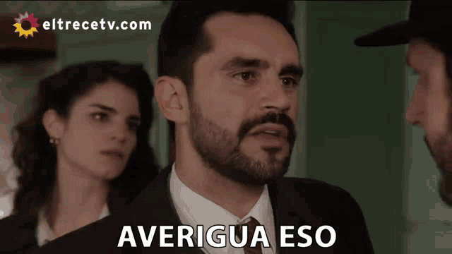 a man in a suit says averigua eso in front of two women