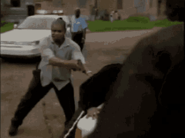 a man is standing in front of a police car holding a gun