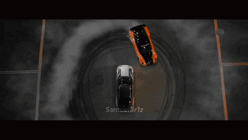 two cars are driving around a circle with smoke coming out of the tire