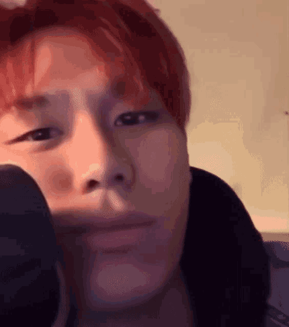 a close up of a person 's face with red hair and a microphone .