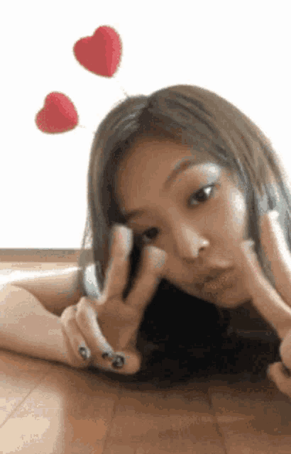 a woman is laying on the floor making a peace sign