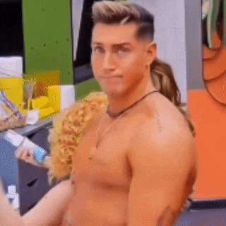 a shirtless man is standing in a room with a woman holding a bottle of toothpaste .