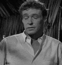 a black and white photo of a man with his eyes closed in a shirt .