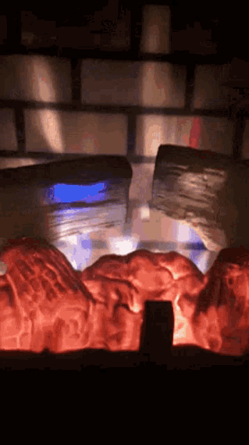 a fireplace with logs burning and a blue light