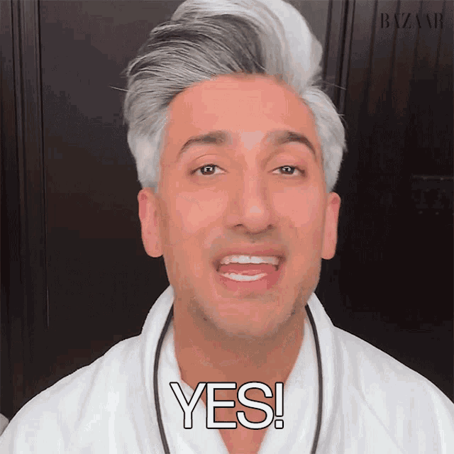 a man with gray hair and a white robe is saying yes