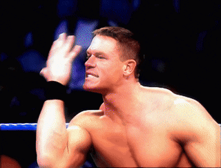 a man without a shirt is in a wrestling ring with his hand up