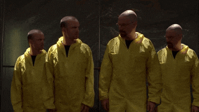 a group of men wearing yellow coveralls are standing in a row