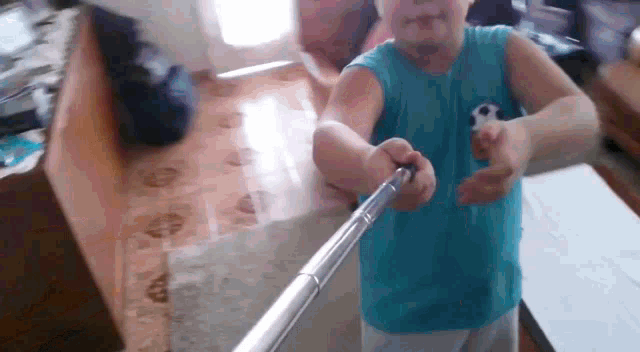 a young boy is holding a selfie stick in his hand .