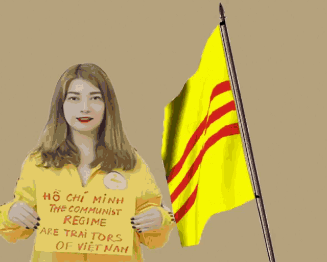 a woman holding a sign that says ho chi minh the communist regime are trai tors of vietnam
