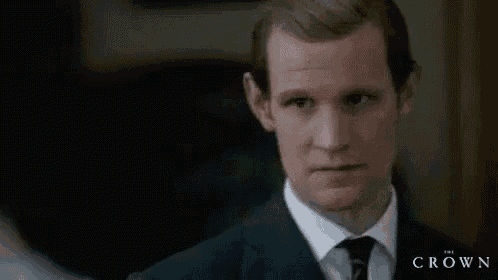 a close up of a man in a suit and tie looking at something .