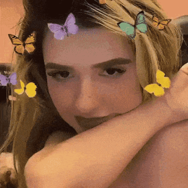 a woman with butterflies in her hair is smiling