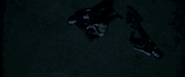 a group of people laying on the ground in a dark room