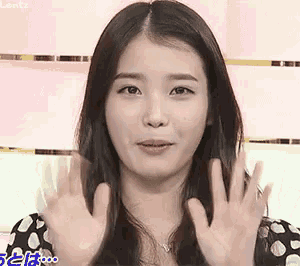 a woman in a polka dot dress is making a face with her hands