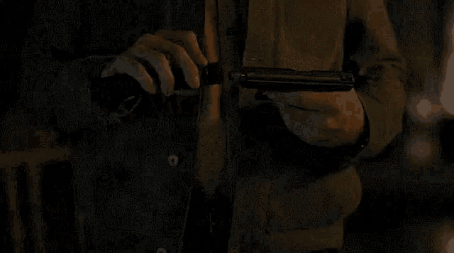 a man is holding a gun in a dark room .