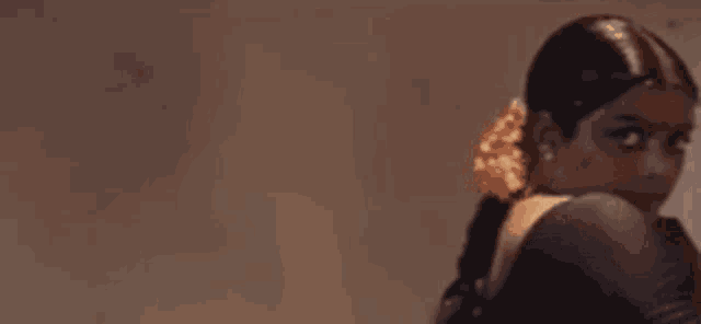 a close up of a woman 's face in a dark room with a shadow on her face .