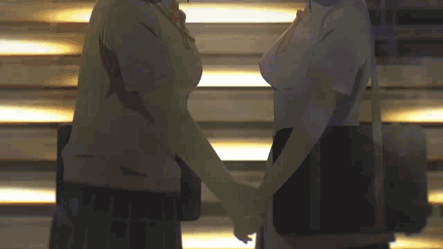 two anime girls are holding hands in front of a building .