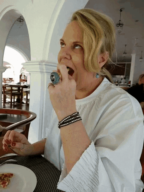 a woman sitting at a table with a plate of food in front of her