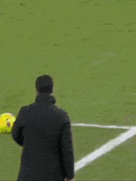 a man is laying on the ground on a soccer field with a soccer ball .