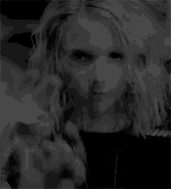 a black and white photo of a woman with long hair holding a knife .