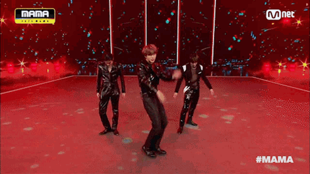 three men are dancing on a stage in front of a sign that says mama on it