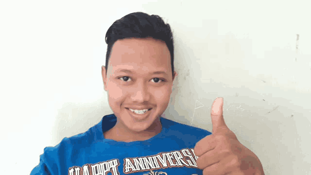 a young man is wearing a blue shirt that says happy anniversary