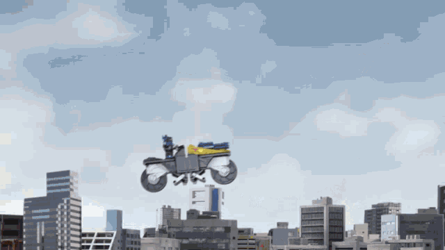 a motorcycle is flying over a city with a blue sky in the background