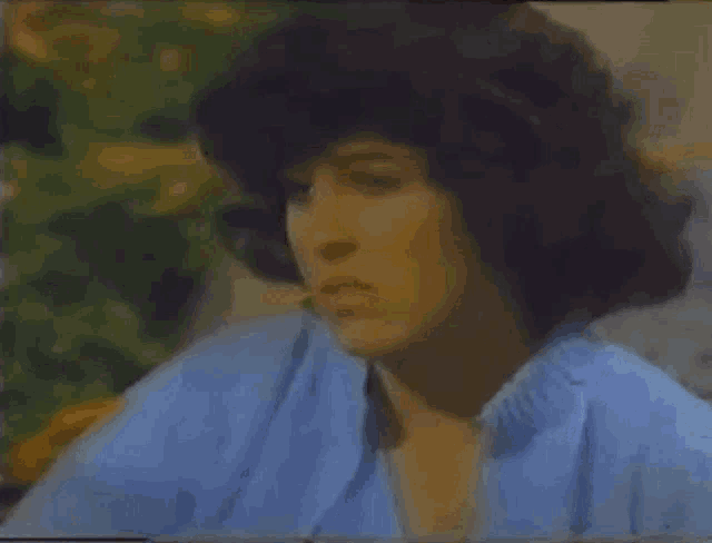 a close up of a woman 's face with a blue shirt on .