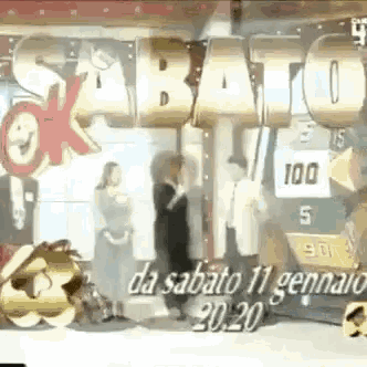 a group of people standing in front of a sign that says sabato da sabato 11 gennaio 2020