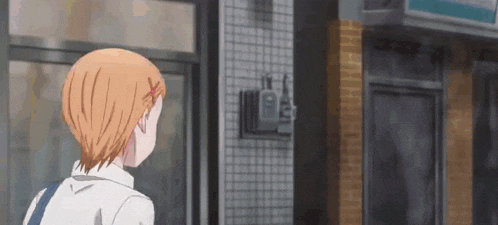 a girl with orange hair is standing in front of a store and looking out the window .