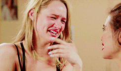 a woman in a black bra is crying while talking to another woman