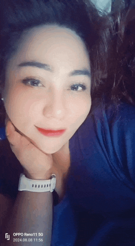 a woman wearing an oppo reno 11 5g phone takes a selfie