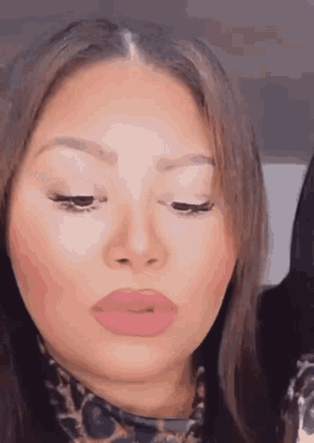 a close up of a woman 's face with pink lipstick and a leopard print shirt .