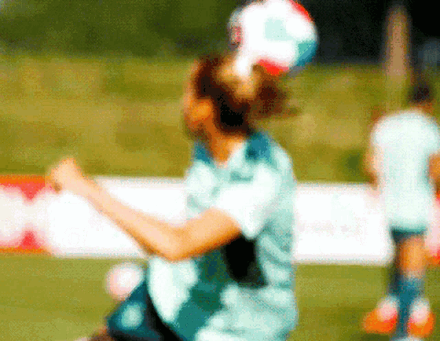a blurry picture of a person playing soccer with a sign in the background that says ' coca cola '