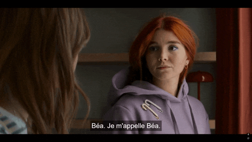 a woman in a purple hoodie is talking to another woman in a foreign language